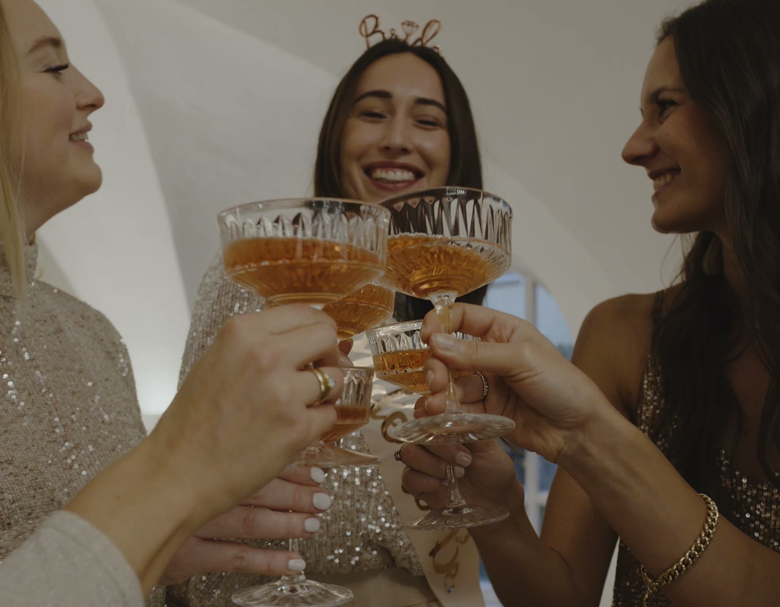Gruppe junger Frauen stoesst bei einer Schminkparty mit Prosecco an